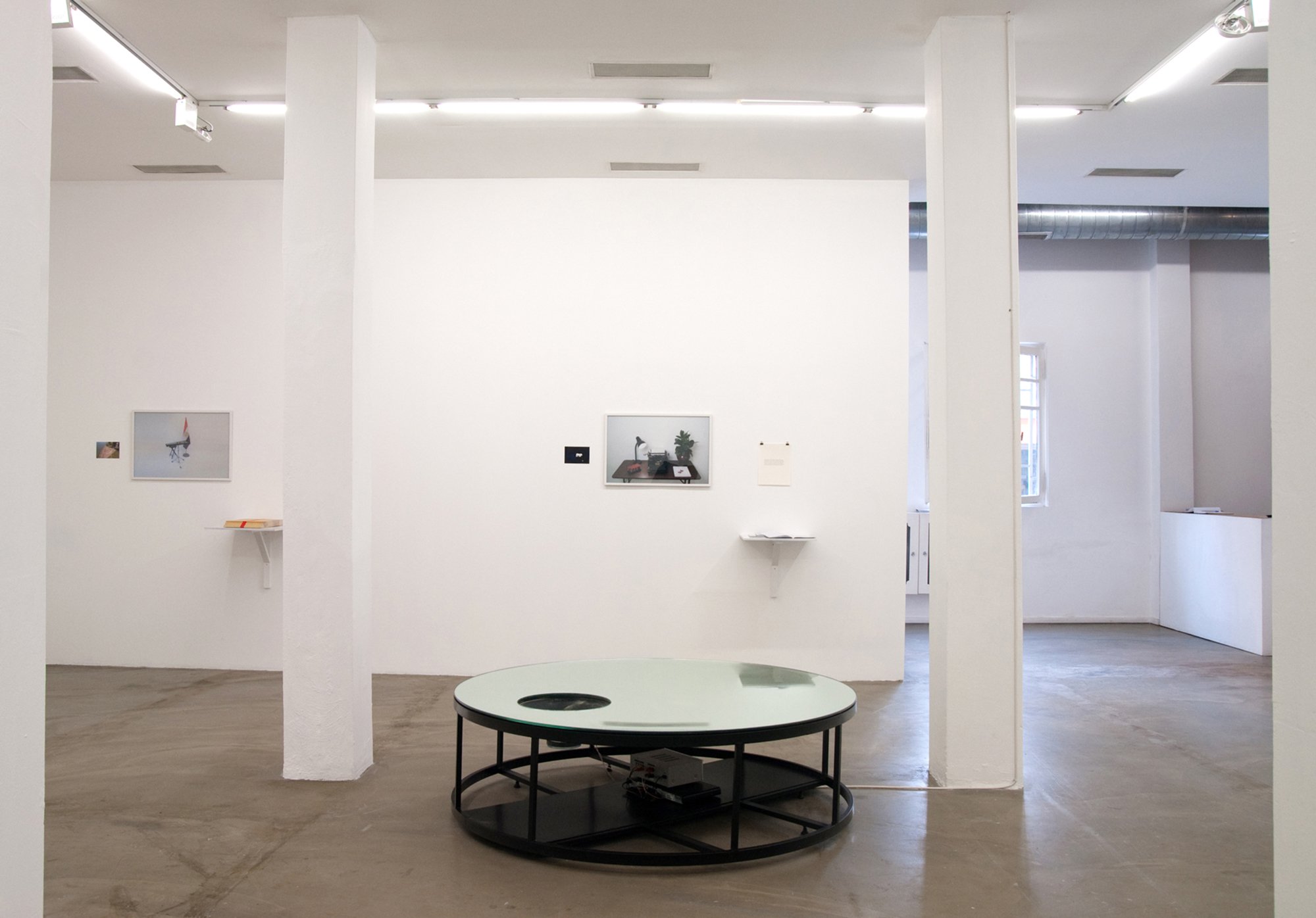 (Centre) Can Altay, Deposit (Spring Deficit: After Dubai, After Hammons and after the politics of white noise), 2010. (On wall) Iman Issa, Triptych #4, photographs, text, notebooks, dimensions variable, 2009. Installation view, Can Atlay – Iman Issa, Rodeo, Istanbul, 2010