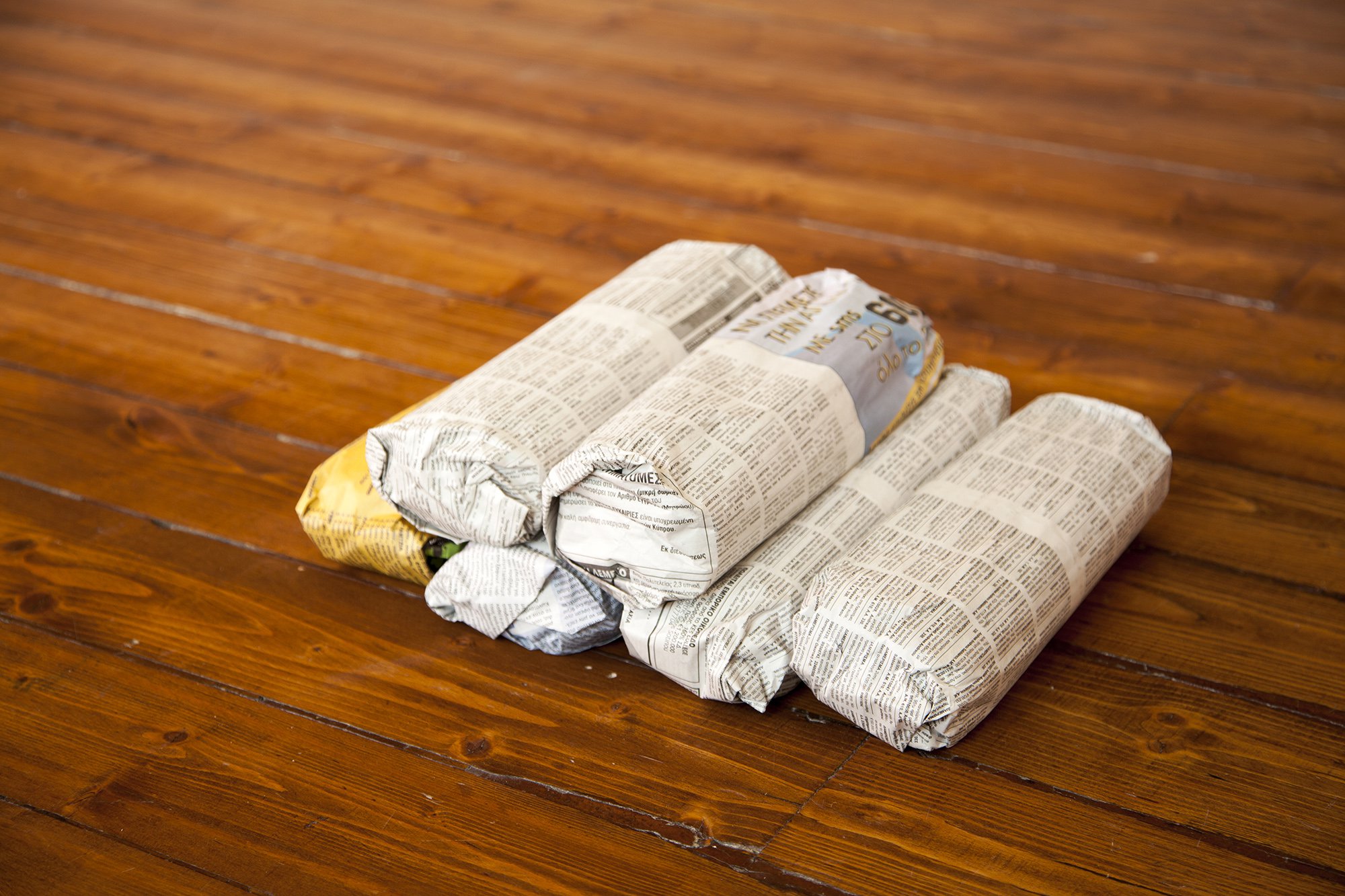 Christodoulos Panayiotou, Untitled, 6 candle bundles wrapped in newspaper of 1 kg each, dimensions variable, 2012