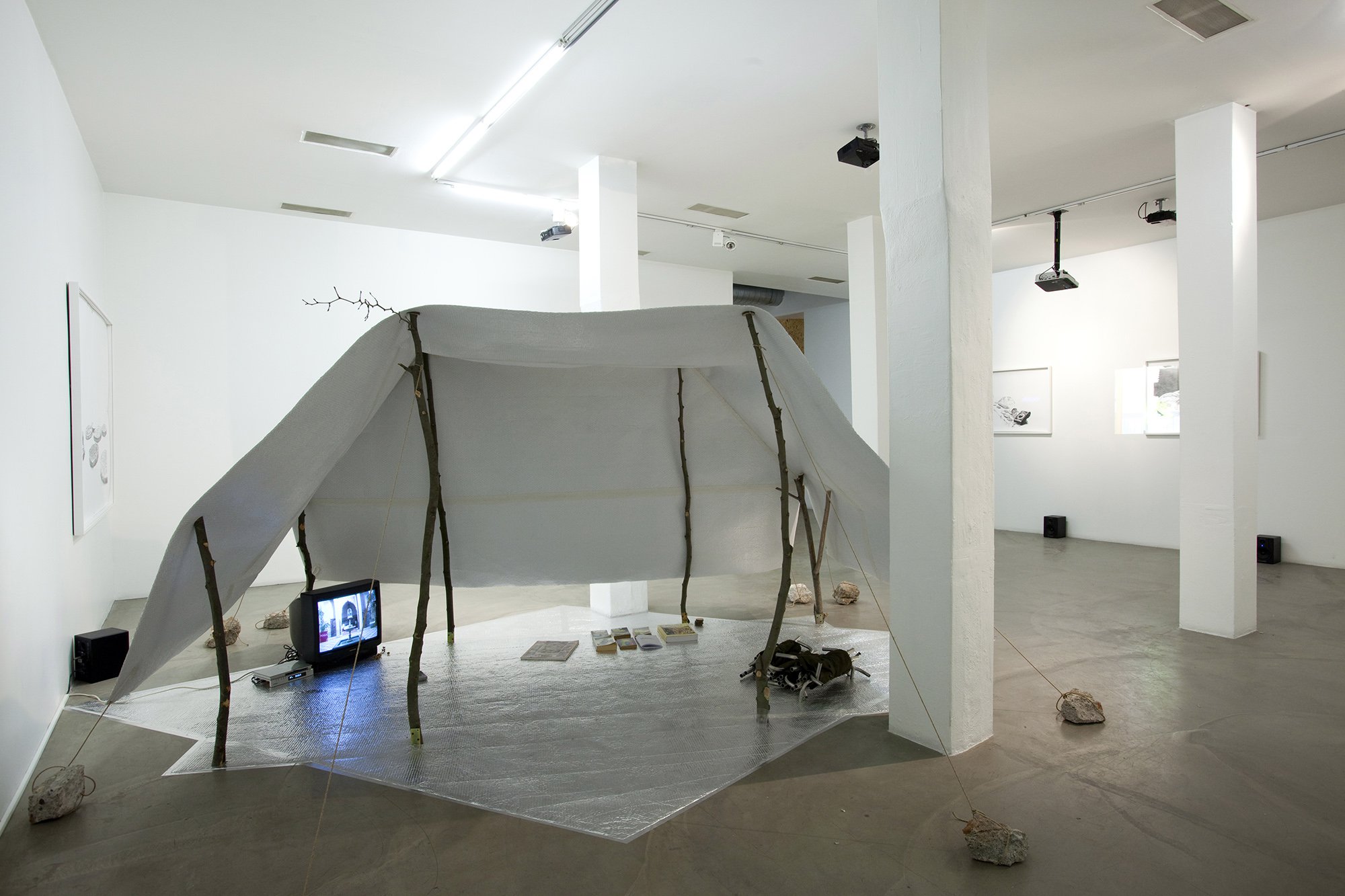 Mark Aerial Waller, The Cassiopeia Plan, thermal insulation foil, training video + instruction video, 3 chairs, 6 books, 2011 – 2012. Installation view, Offering Transmissions, Rodeo, Istanbul, 2012