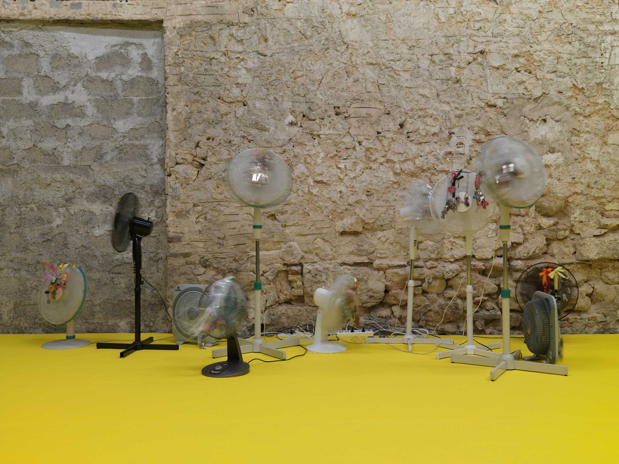 Iris Touliatou, EMOTIONAL INFINITY (THE SOUND OF THEM COMING BACK AMPLIFIED AND LOOPED), oscillating fans, duplicated house keys, pre owned key chains, string, ribbons, gift bows, wire, timers, multiplugs, outlets, dimensions variable, 2022