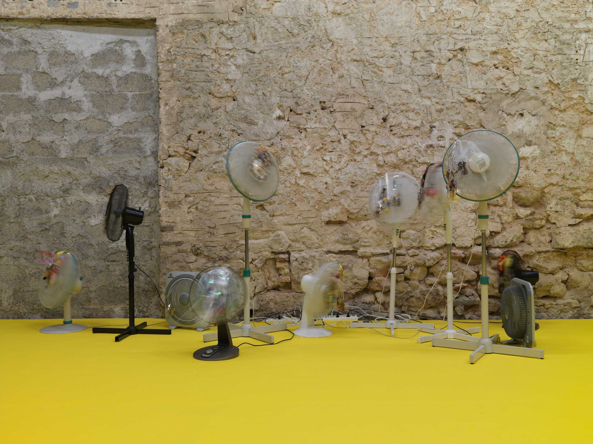 Iris Touliatou, Emotional Infinity (The sound of them coming back amplified and looped), oscillating fans, house keys, key chains, string, ribbons, gift bows, wire, timers, multiplugs, outlets, dimensions variable, 2022. Installation view, anabasis*, Rodeo, Piraeus, 2022