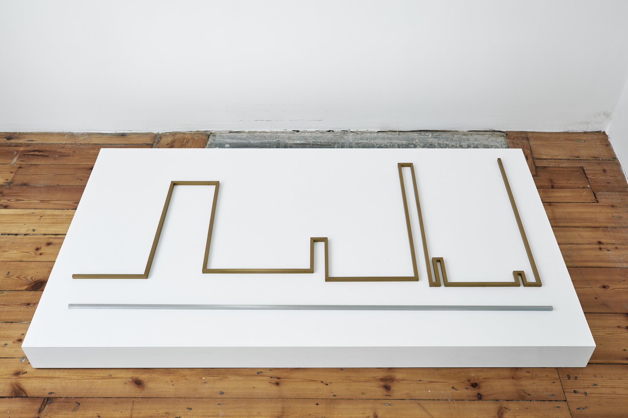 Iman Issa, Seduction (study for 2014), bronze and aluminum sculpture, text panel under glass, white plinth, sculpture: 62.5 x 124 cm (24 5/8 x 48 7/8 in), plinth: 9 x 140.5 x 80 cm (3 1/2 x 55 1/4 x 31 1/2 in), 2014